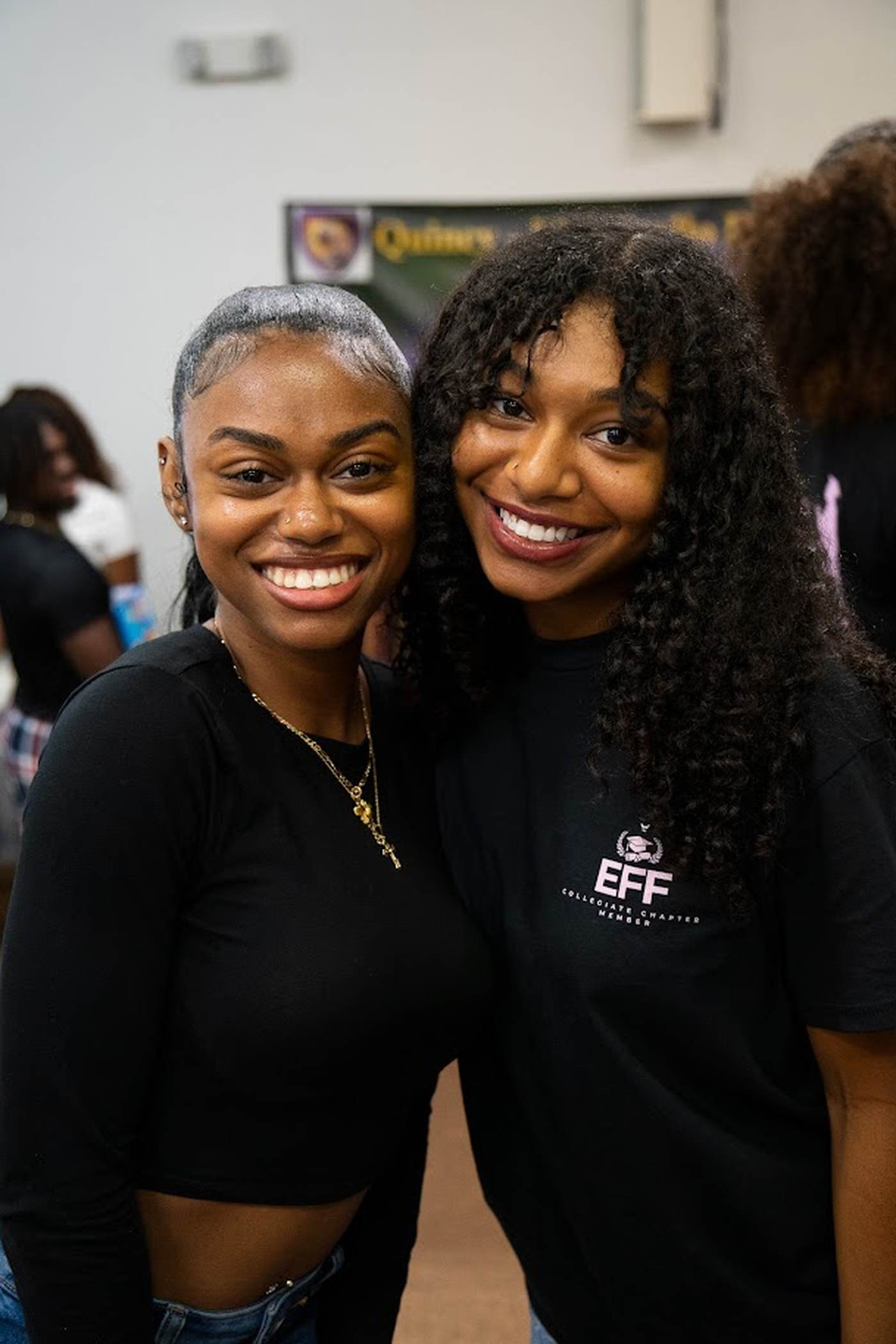 Two smiling students, one wearing an EFF Collegiate Chapter Member shirt