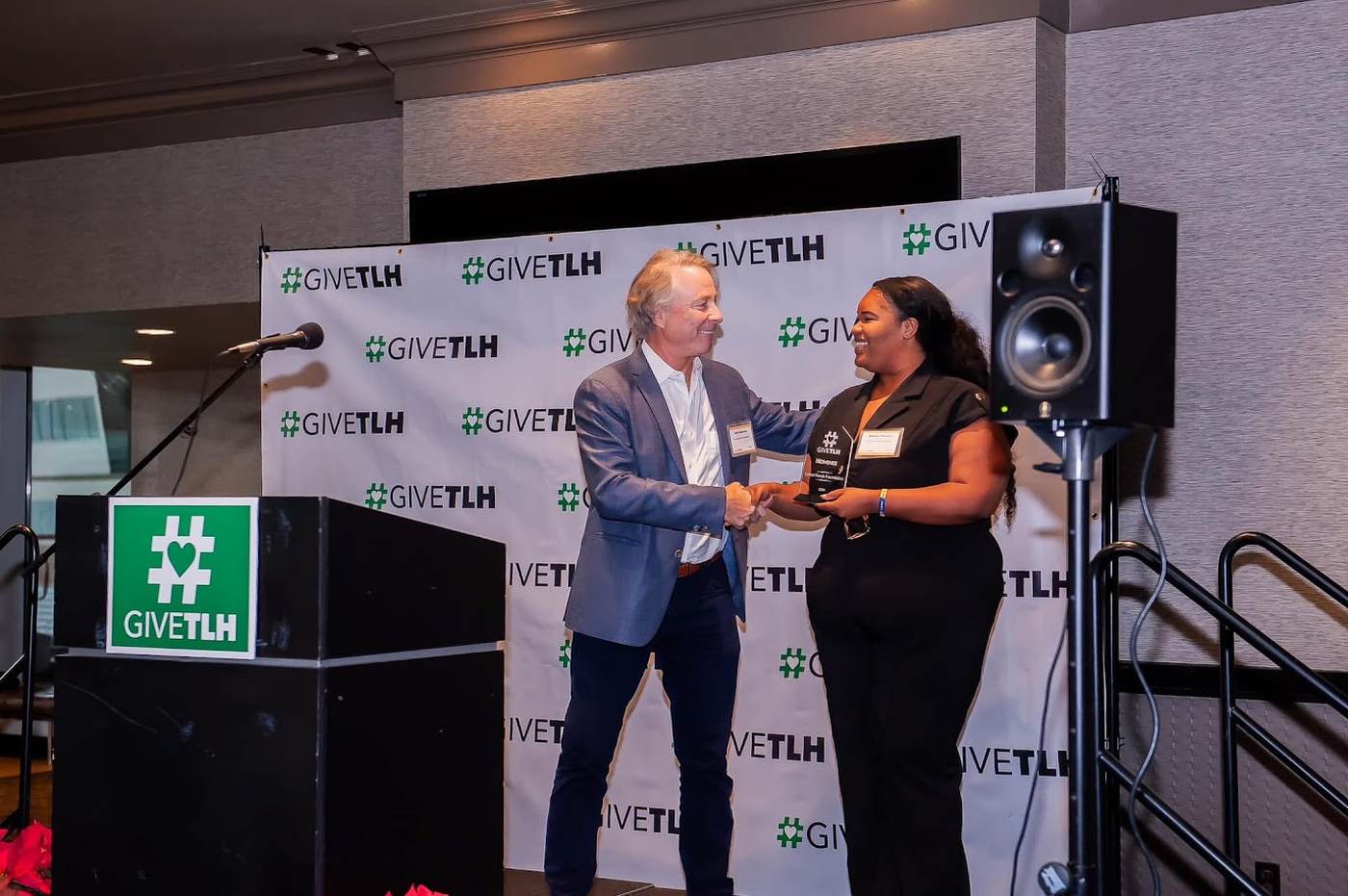 An EFF representative receiving a GiveTLH nominee award on stage